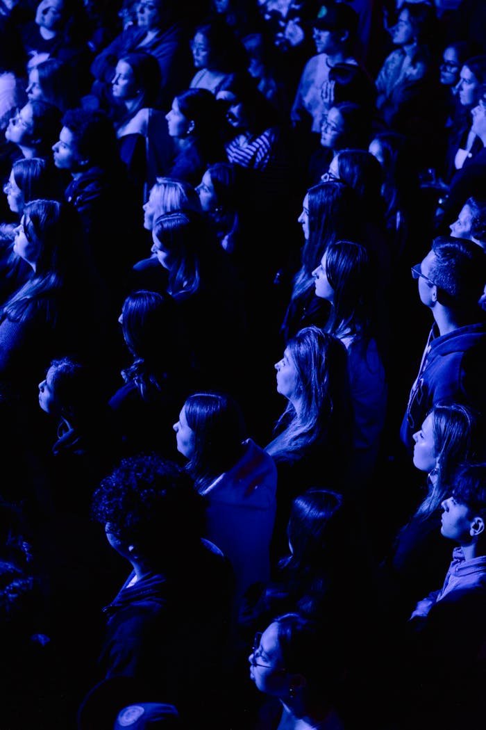 Dynamic crowd immersed in vibrant blue lighting at a live concert.