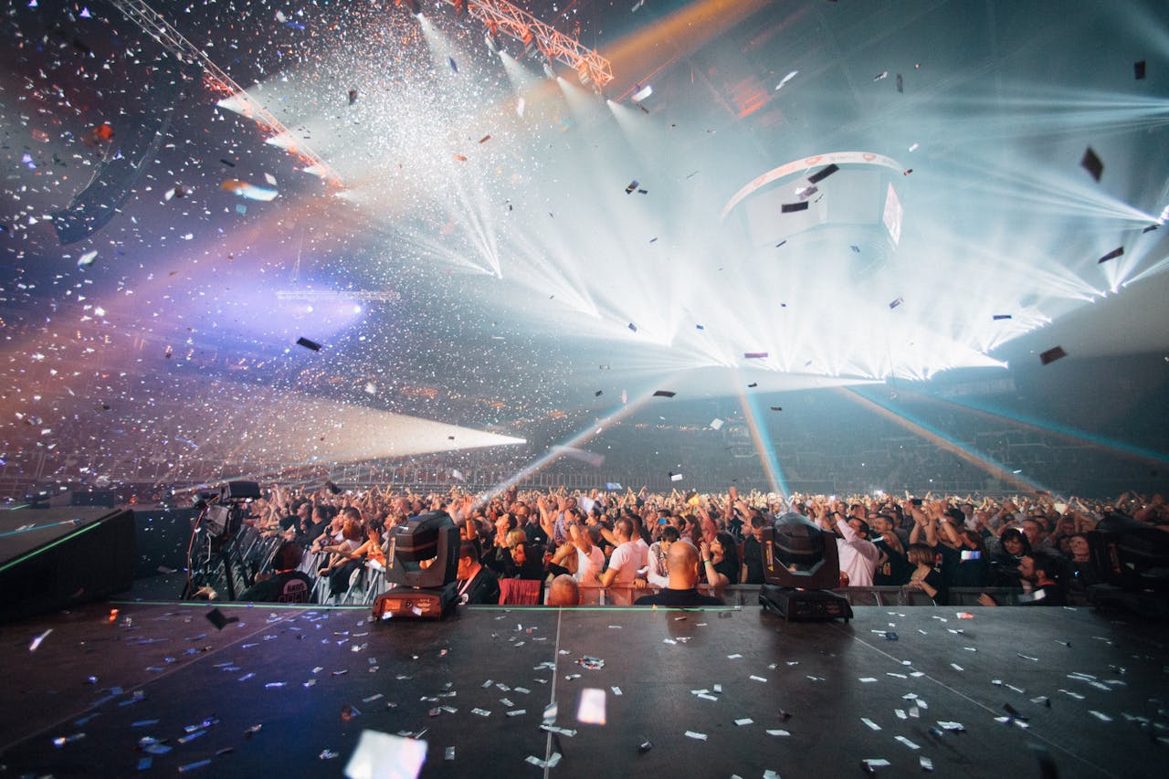 Dynamic concert scene with vibrant lighting, an enthusiastic crowd, and celebratory confetti.
